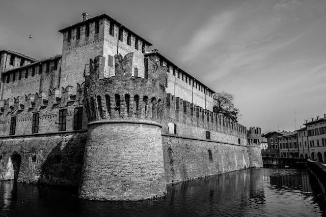 Black and white picture of a castle with a moat